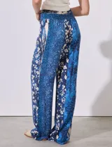 Pantalón largo de rayón con estampado floral en tonos azules y blancos. Tiene pretina ancha elastizada con punto smock.