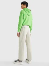 Pantalón de algodón elástico color crema con estampado integral de monogramas TH tonales en jacquard. Tiene dos bolsillos abiertos en la cadera y dos bolsillos traseros con botón.