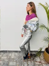 Pantalón de cuero metalizado en color celeste brillante, de corte recto con aberturas en los tobillos y tiro medio.