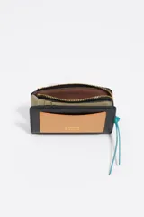 Billetera compacta de cuero vacuno en color negro, con cierre superior metálico dorado y logo de la marca estampado en el frente.