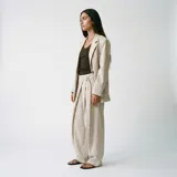 Blazer de corte sastrero en color beige con estampado de rayas verticales finas, diseño de solapas clásicas y cierre frontal con botones.