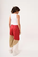 Pantalón de tiro alto con corte palazzo, color beige con bloques de color en marrón claro y blanco.
