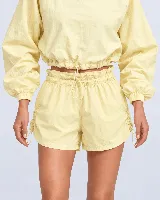 Short amarillo de poliéster y poliamida, con cintura clochard ajustable con cordón, bolsillos laterales y cordones de ajuste laterales para fruncir.