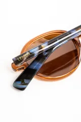 Lentes de sol polarizados con armazón redondo de acetato en color marrón translúcido y micas en tono ámbar.