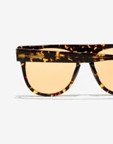 Lentes de sol unisex Hawkers modelo La Noire Eco, con montura carey y lentes color naranja.