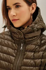Campera puffer negra con capucha, cierre frontal con doble cremallera y diseño entallado en la cintura.