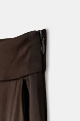 Pantalón de vestir fluido de tiro alto, confeccionado en mezcla de viscosa. Presenta pinzas en el delantero y cierre lateral con cremallera oculta.