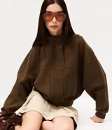 Campera marrón estilo bomber, confeccionada en punto roma, con cuello alto, mangas largas, cierre frontal oculto, bolsillos frontales aplicados y recortes en el pecho.