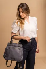 Cartera mochila de diseño versátil, color rosado, confeccionada en material sintético impermeable. Cuenta con doble asa superior, correas ajustables para usar como mochila, compartimento principal con cierre y bolsillo frontal con cierre decorado con tirador largo.