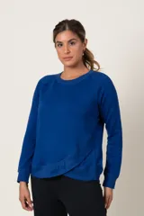 Buzo deportivo celeste de algodón, con cuello redondo y terminación en volado cruzado en el ruedo.