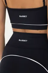 Calza larga de lycra negra con cintura alta y vivos blancos en la parte posterior.