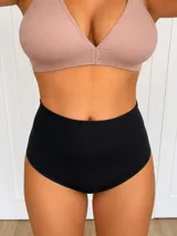 Bombacha de tiro alto con efecto reductor y modelador, confeccionada en microfibra lisa de color negro.