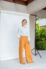 Pantalón de corte sastrero con cintura alta, pinzas delanteras y pierna ancha.