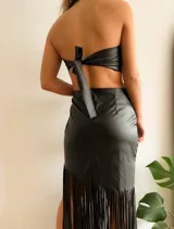 Vestido midi negro de cuerina, corte recto, sin mangas, escote recto, con aberturas laterales en la cintura y flecos en el ruedo.