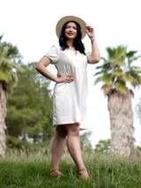 Vestido blanco de broderie con escote en V y mangas cortas.