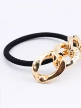 Colero de pelo con elástico negro y aplique de cadena dorada.