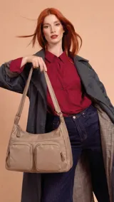 Bandolera de tafeta impermeable color beige, con dos bolsillos frontales con cierre, compartimento principal con cierre y correa regulable.