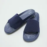 Chanclas de piscina azules con base plana y tira ancha con textura acanalada.