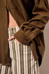 Camisa de lino y viscosa color marrón, con bolsillos frontales ojal, mangas largas y corte oversize.