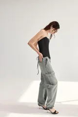 Jeans cargo de tiro medio y corte holgado en color gris con efecto deslavado. Cuenta con bolsillos laterales con solapa y cierre frontal de cremallera y botón metálico.
