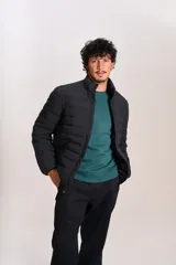 Campera acolchada negra con cierre frontal, cuello alto y diseño de costuras horizontales. Presenta un ajuste entallado y tejido exterior resistente al agua.