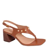 Sandalias de cuero color suela con taco medio ancho, puntera cuadrada y tira en T decorada con tachas esféricas doradas. Cuenta con tira ajustable al talón con hebilla metálica.