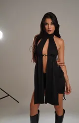 Top negro con cuello halter, abertura en el pecho y falda corta con cordones laterales.