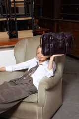 Cartera tipo bolso de mano y hombro de cuero color bordó, con diseño estructurado, doble asa corta y detalles de correas con hebillas metálicas en el frente.