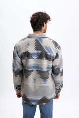 Sobrecamisa de hombre con estampado tribal en tonos gris claro, azul y marrón, de manga larga, cuello clásico, bolsillos frontales con solapa y cierre de botones.