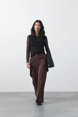 Pantalón wide leg color marrón chocolate, de tiro medio y corte relajado. Presenta detalle de hebillas laterales con ojales metálicos en la cintura y una caída fluida.