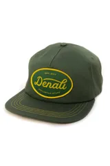 Gorra verde militar de gabardina con parche ovalado amarillo y texto bordado en verde y amarillo.