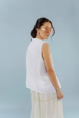 Chaleco color amarillo pastel de lino, sin mangas, con cuello solapa y cierre frontal con dos botones.