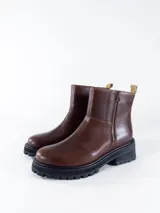 Bota marrón de cuero con cierre lateral, suela track y tirador trasero.