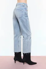 Jean de denim 100% algodón, color celeste, de calce Mom y tiro medio. Cuenta con remaches de flores niquel en borde de bolsillos delanteros y traseros, presillas delanteras y presilla central de espalda.
