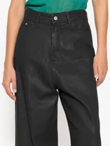 Pantalón de jean negro engomado de tiro alto, corte oversize y pierna ancha.