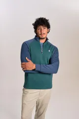 Buzo de cuello alto con cierre frontal parcial, diseño bicolor con cuerpo en verde y mangas raglán en azul. Presenta el logo de la marca bordado en el pecho.