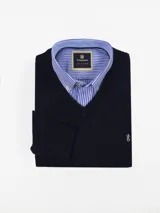 Sweater azul marino de punto con cuello en V. Incluye camisa celeste a rayas con cuello abotonado.