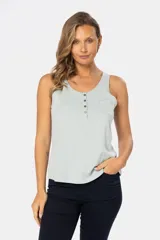 Musculosa blanca sin mangas, de corte clásico y calce cómodo, confeccionada en tejido suave. Presenta escote redondo, cartera con botones frontales y un pequeño bolsillo aplicado en el pecho.