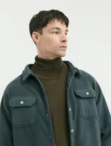 Sobrecamisa de micropolar color terracota, con cuello camisero, cierre frontal con botones a presión y dos bolsillos frontales con solapa y botón.