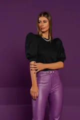 Pantalón skinny de cuero sintético color violeta, con talle alto, cinturón con hebilla metálica y detalle de tachas en el ruedo.
