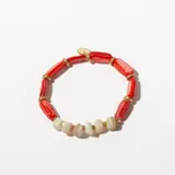 Pulsera elástica con cuentas tubulares rojas y doradas, y cuentas de piedra irregulares color crema.