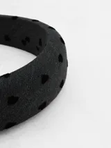 Vincha acolchada de color gris oscuro con estampado de pequeños corazones negros.