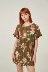 Vestido corto de viscosa con estampado floral en tonos verdes, rojos y blancos. Presenta un diseño holgado con cuello a la base y mangas cortas con volados en los extremos.