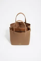 Bolso grande Bimba y Lola color marrón, con exterior de gabardina y detalles en cuero vacuno. Presenta doble asa de mano, correa ajustable, cierre con botón a presión, logo metálico de la marca en dorado y bolsillo interior con cremallera.