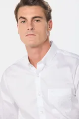 Camisa celeste lisa de corte clásico con cuello abotonado y bolsillo en el pecho.