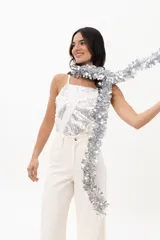 Jean de corte wide leg en color blanco, confeccionado en algodón con textura de pequeños cortes lineales en toda la superficie. Presenta tiro medio, cierre frontal con botón y bolsillos laterales.