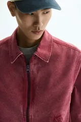 Campera de algodón color rosa con efecto acid wash, cierre frontal, cuello camisero, bolsillos delanteros ribeteados y puños con botón.