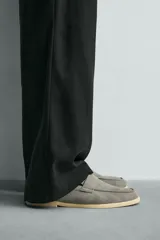 Mocasín casual de hombre, color marrón oscuro (bordó), fabricado en piel con acabado serraje (gamuza). Presenta un detalle de antifaz en el empeine y suela a contraste de color beige claro.
