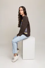 Sweater de mohair marrón con diseño geométrico en azul y amarillo.