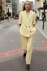 Pantalón de vestir amarillo pálido, de tiro alto, corte recto y largo a la altura del tobillo.